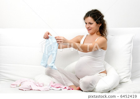 Beatiful pregnant woman looking at babys clothes Beatiful pregnant woman looking at babys clothes 6452419