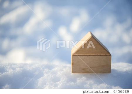 A wooden block house placed on the snow A wooden block house placed on the snow 6456989