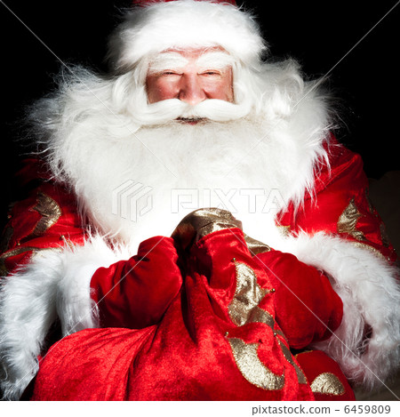 Santa sitting at the Christmas room and looking into the sack Santa sitting at the Christmas room and looking into the sack 6459809
