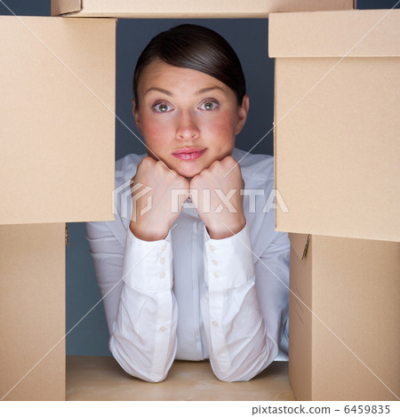 Portrait of young woman surrounded by lots of boxes. Lots of wor 6459835