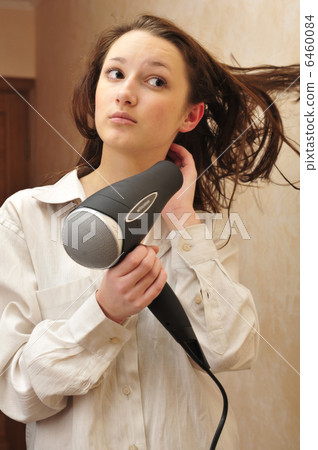 Beautiful woman drying her hair with hairdryer 6460084