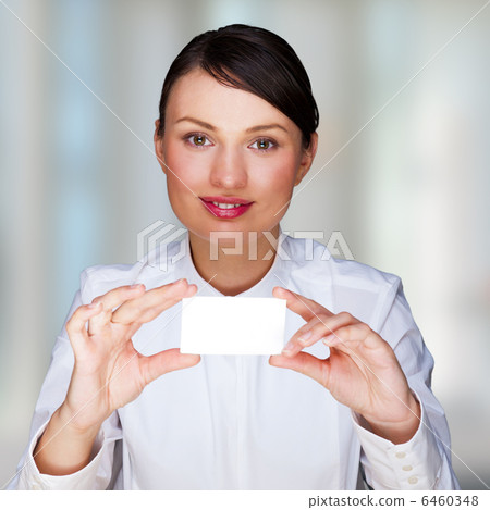 Young businesswoman showing her business card - sitting at her o Young businesswoman showing her business card - sitting at her o 6460348