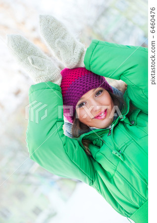 Young beautiful woman wearing winter clothing and playing outdoo 6460476
