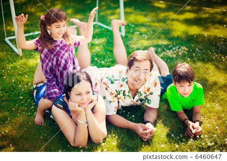 Artistic lifestyle photo of full happy family laying relaxed on 6460647