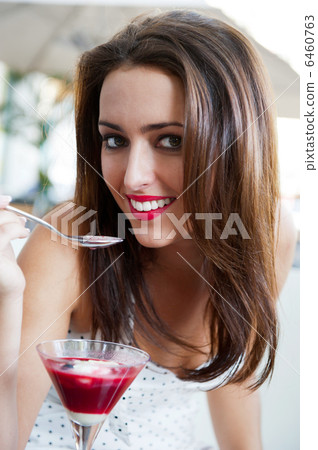 Portrait of an young beautiful woman eating an ice cream in cafe Portrait of an young beautiful woman eating an ice cream in cafe 6460763