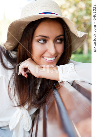 Portrait of a sexy young female smiling in a park while sitting Portrait of a sexy young female smiling in a park while sitting 6461022