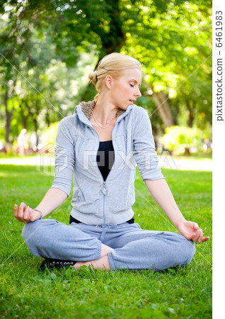 Portrait of young woman meditating in pose of lotus on green gra Portrait of young woman meditating in pose of lotus on green gra 6461983