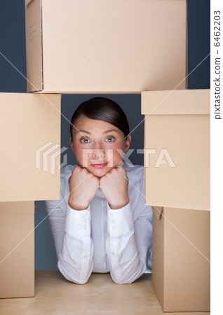 Portrait of young woman surrounded by lots of boxes. Lots of wor 6462203