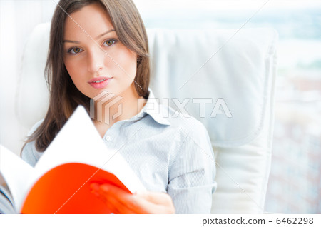 Portrait of a sensual young woman reading a novel while sitting Portrait of a sensual young woman reading a novel while sitting 6462298
