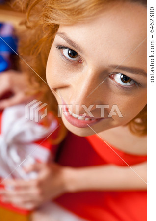 Christmas woman near a Christmas tree holding big gift box while Christmas woman near a Christmas tree holding big gift box while 6462300