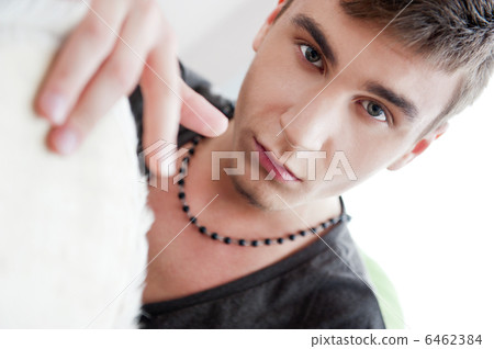 Happy young handsome man at home, smiling and playing arabic tra 6462384