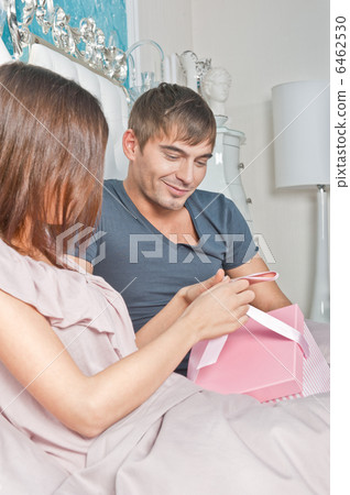 Young happy couple presenting gift in bed 6462530