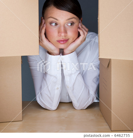Portrait of young woman surrounded by lots of boxes. Lots of wor 6462735