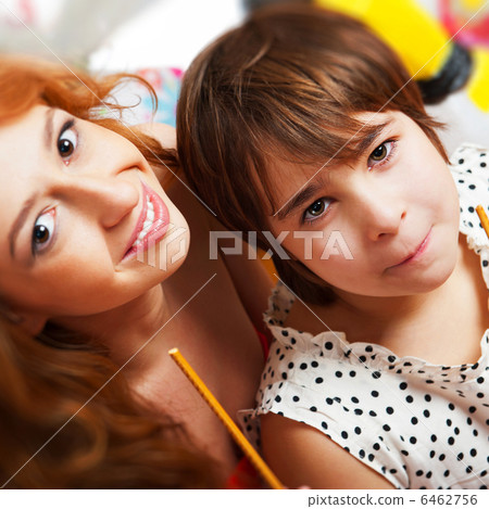 Mother and her daughter sitting together near christmas tree Mother and her daughter sitting together near christmas tree 6462756