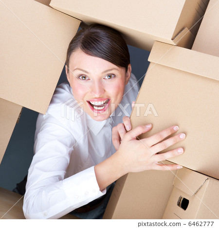 Portrait of young woman surrounded by lots of boxes. Lots of wor 6462777