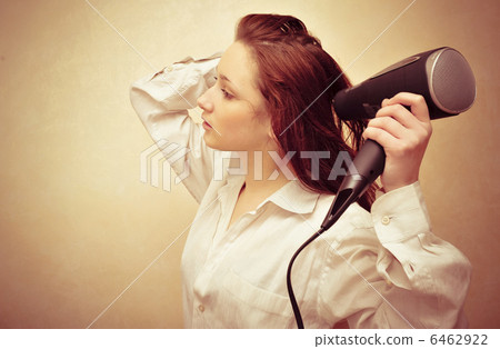 Beautiful woman drying her hair with hairdryer 6462922