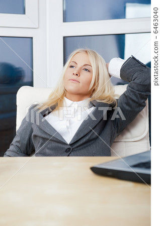 Happy business woman in the office resting and daydreaming Happy business woman in the office resting and daydreaming 6463040