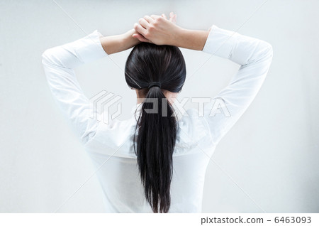 Rear view of young business woman with hands behind head Rear view of young business woman with hands behind head 6463093