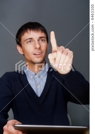 Young business man pressing a touchscreen button while working a Young business man pressing a touchscreen button while working a 6463100