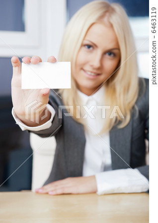 Young businesswoman showing her business card - sitting at her o 6463119