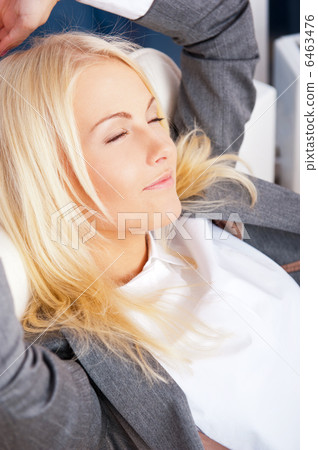 Happy business woman in the office resting and daydreaming 6463476