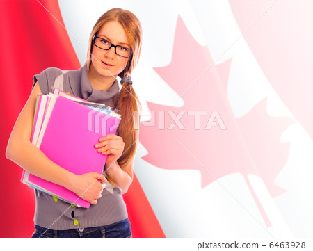 Portrait of pretty young woman holding book in her arms. Canadia 6463928