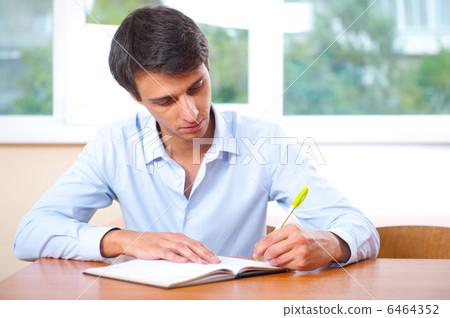 Businessman sitting indoors and writing plan in his diary 6464352