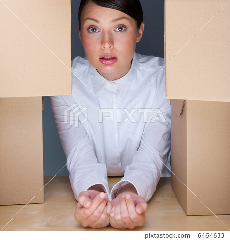 Portrait of young woman surrounded by lots of boxes. Lots of wor 6464633