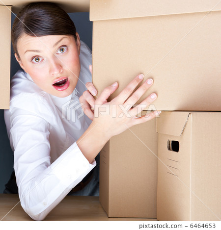 Portrait of young woman surrounded by lots of boxes. Lots of wor 6464653