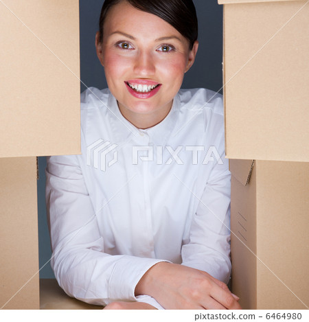 Portrait of young woman surrounded by lots of boxes. Lots of wor 6464980