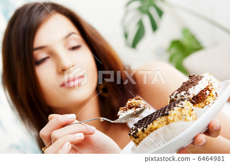Young beautiful woman with a cake. Closeup portrait. Sitting on 6464981