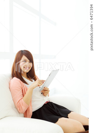 使用平板電腦的長頭髮女人 使用平板電腦的長頭髮女人 6471394