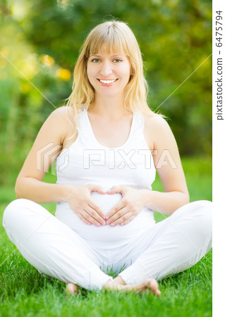 Pregnant woman holding hands on belly Pregnant woman holding hands on belly 6475794