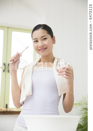 A young woman brushing a tooth 6478118