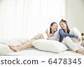 Two young women relaxing at bed 6478345