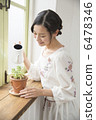 A young woman standing at the window side 6478346