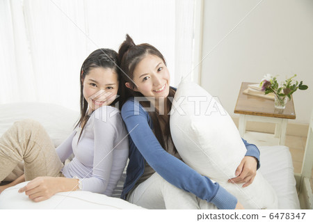 Two young women relaxing at bed 6478347
