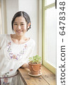 A young woman standing at the window side 6478348