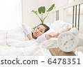 A young woman waking up in bed 6478351