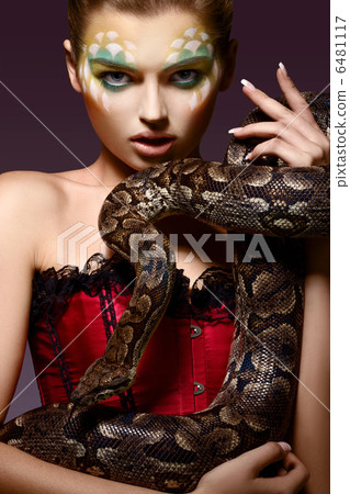Serpent. Fantasy. Fancy Woman holding Tamed Snake in Hands Serpent. Fantasy. Fancy Woman holding Tamed Snake in Hands 6481117