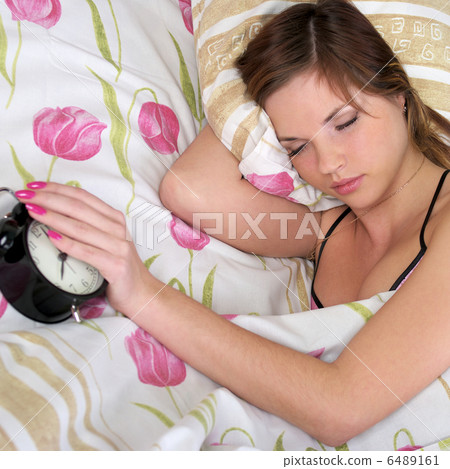 Woman sleep in bed with alarm in the hand Woman sleep in bed with alarm in the hand 6489161