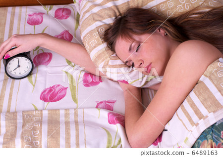 Woman sleep in bed with alarm in the hand Woman sleep in bed with alarm in the hand 6489163