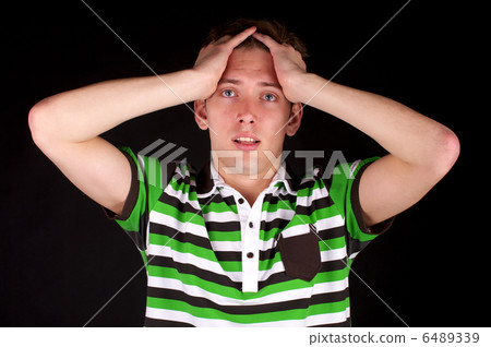 Young unhappy guy holds his head 6489339