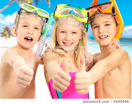 Happy children with thumbs-up gesture at beach 6499496