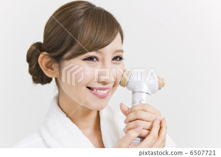 A woman using a facial instrument A woman using a facial instrument 6507721