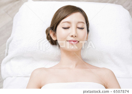 A woman lying on her back with a bath towel 6507874