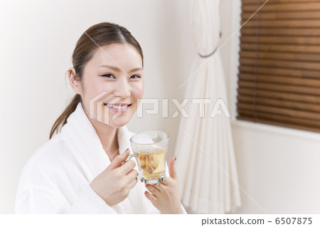 A woman in a bathrobe drinking herbal tea 6507875