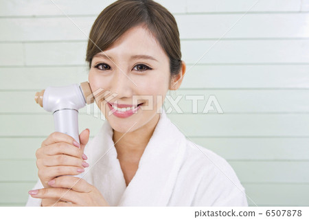 A woman using a facial instrument 6507878
