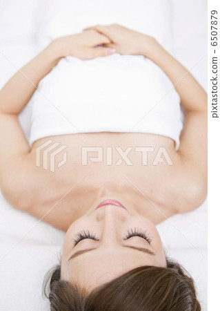 A woman lying on her back with a bath towel 6507879