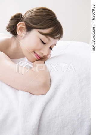 A woman closing her eyes with her face lying down A woman closing her eyes with her face lying down 6507933